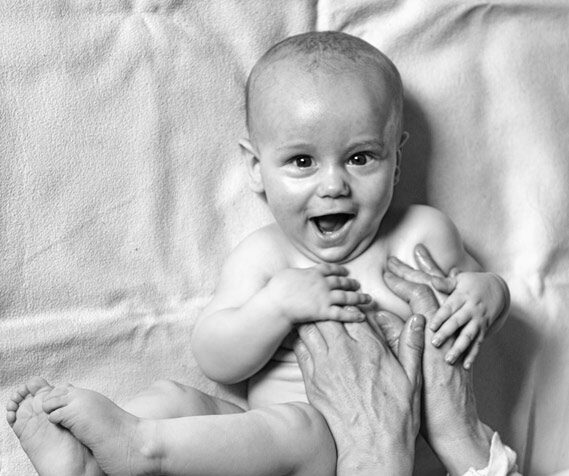 Lachendes Baby bei der Baby-Massage